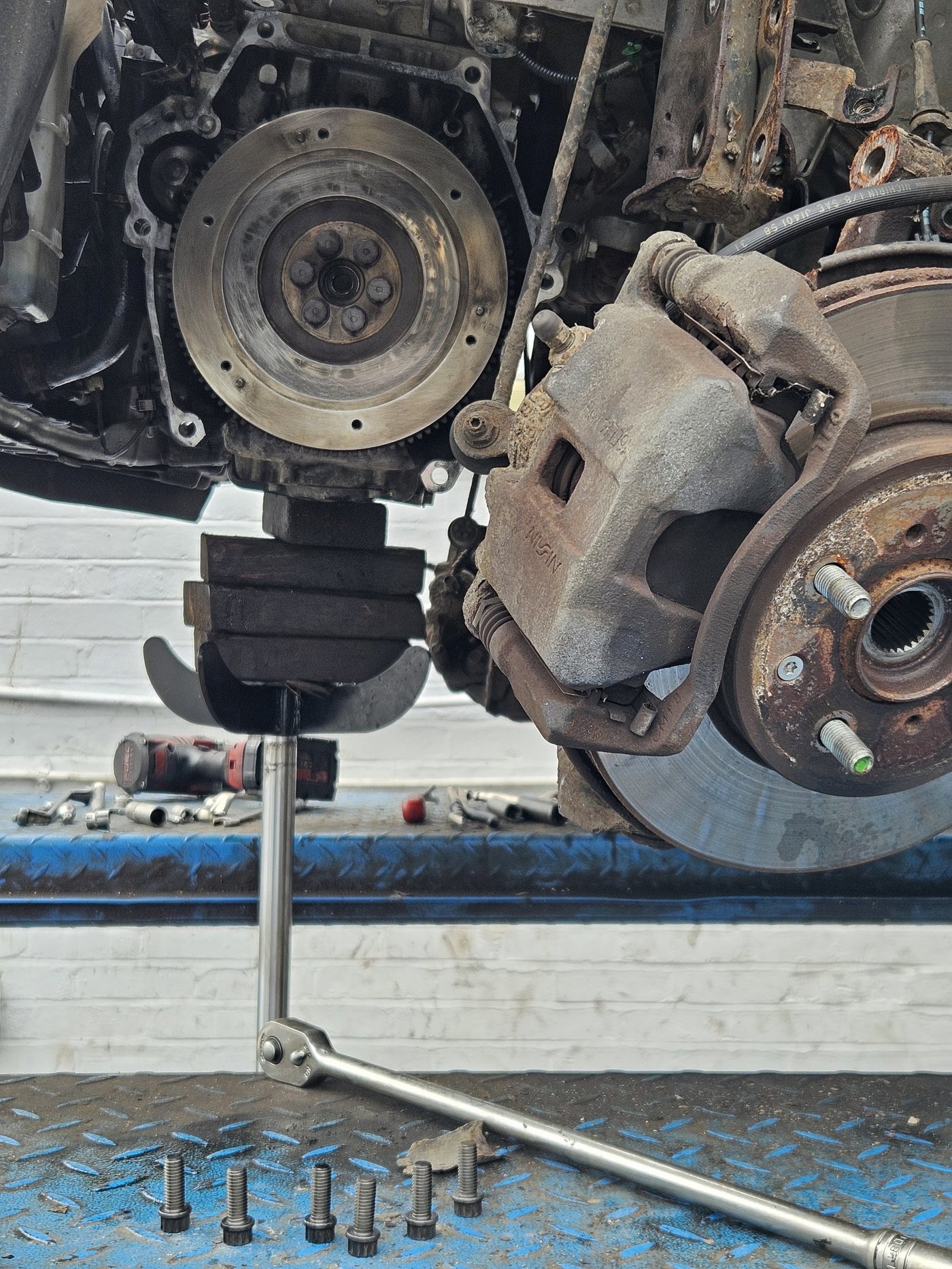 Brake caliper, disc and flywheel on a car up on the ramp at Khalsa Automobile Engineering