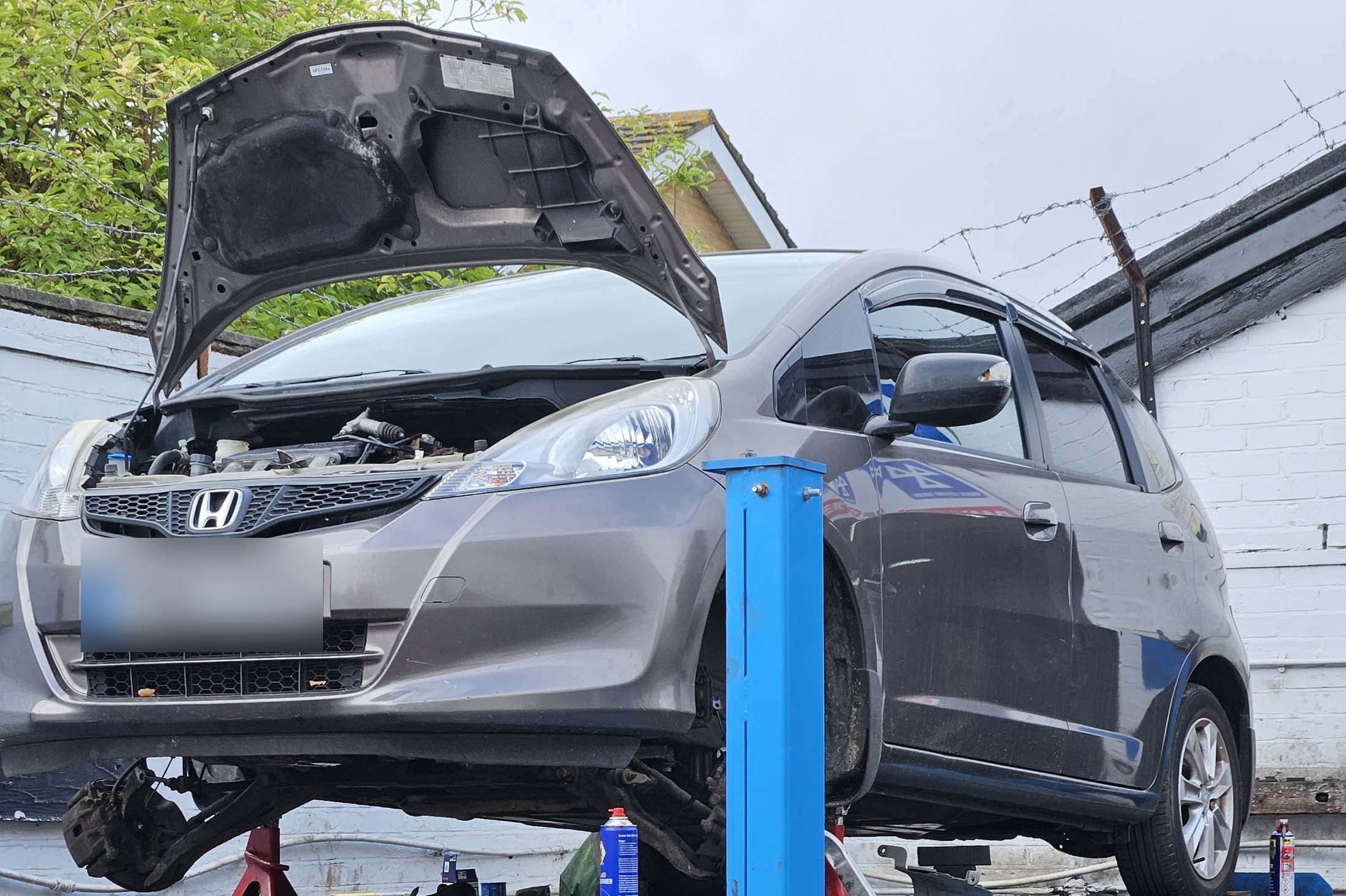 A Honda up on the ramp mid-service at Khalsa Automobile Engineering, Wellington Road, East Ham